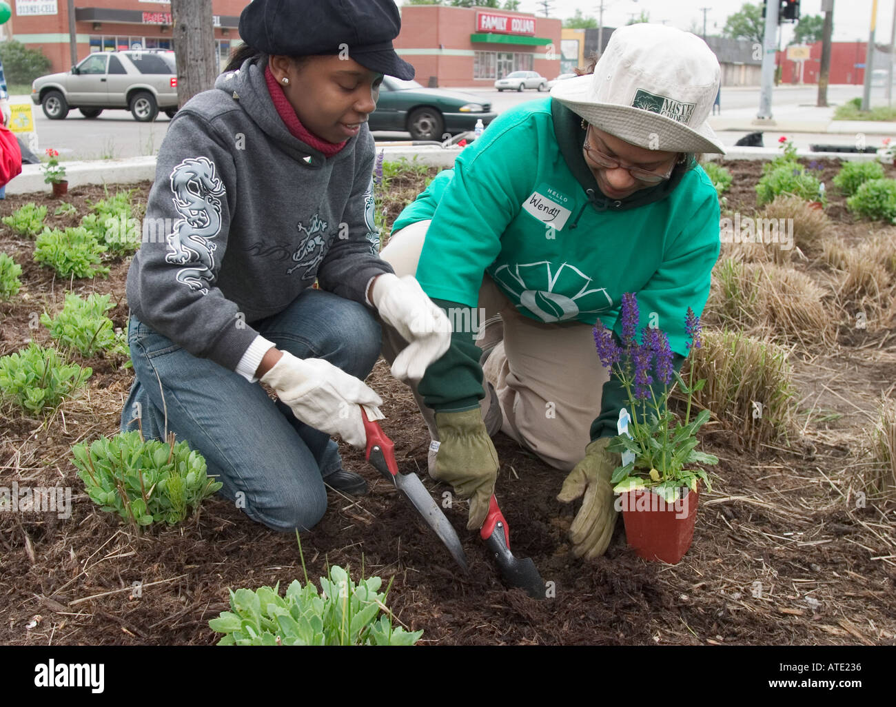 Voluteers nettoyer et planter des fleurs dans le parc de quartier à Detroit Banque D'Images