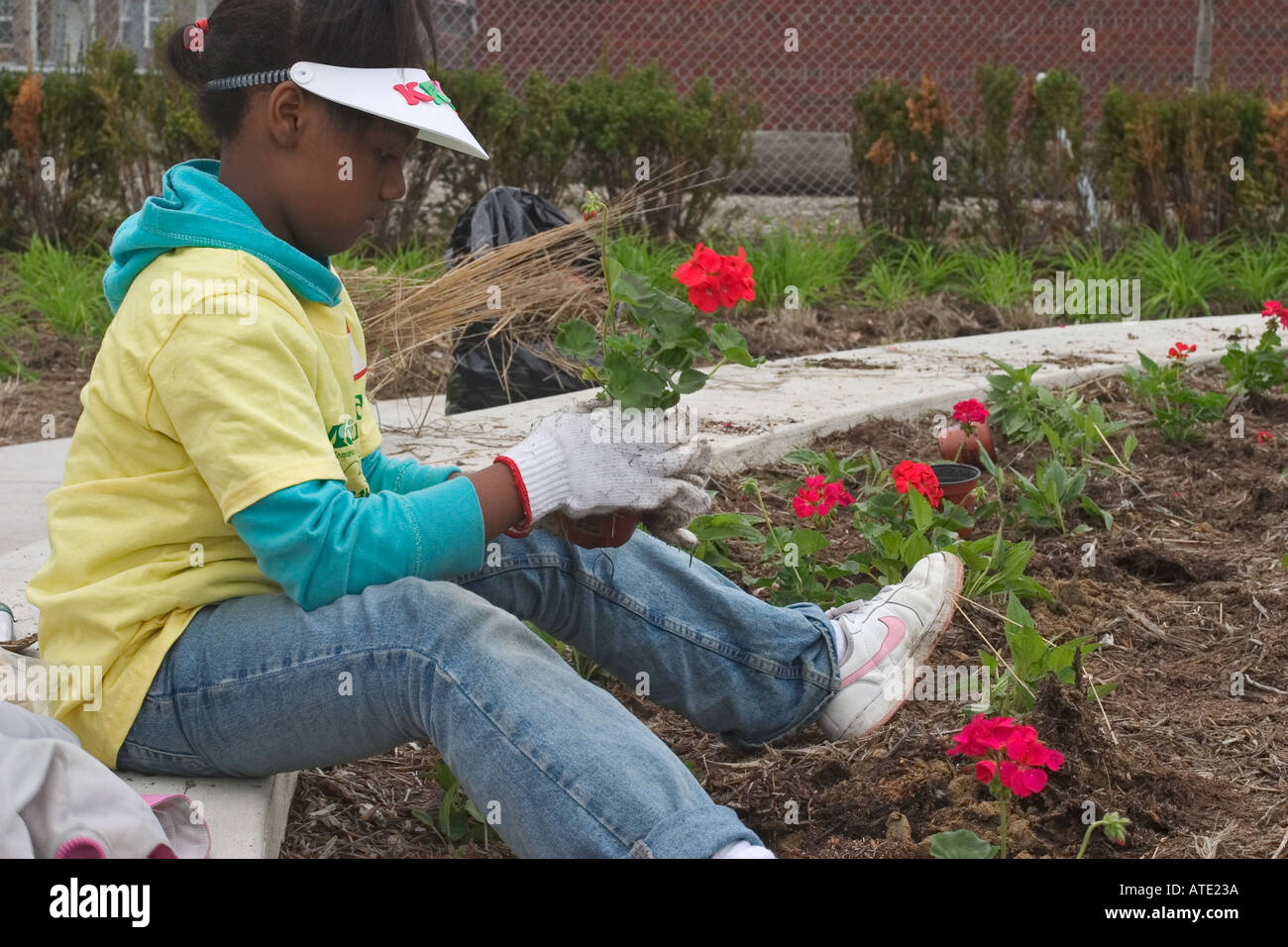 Voluteers nettoyer et planter des fleurs dans le parc de quartier à Detroit Banque D'Images