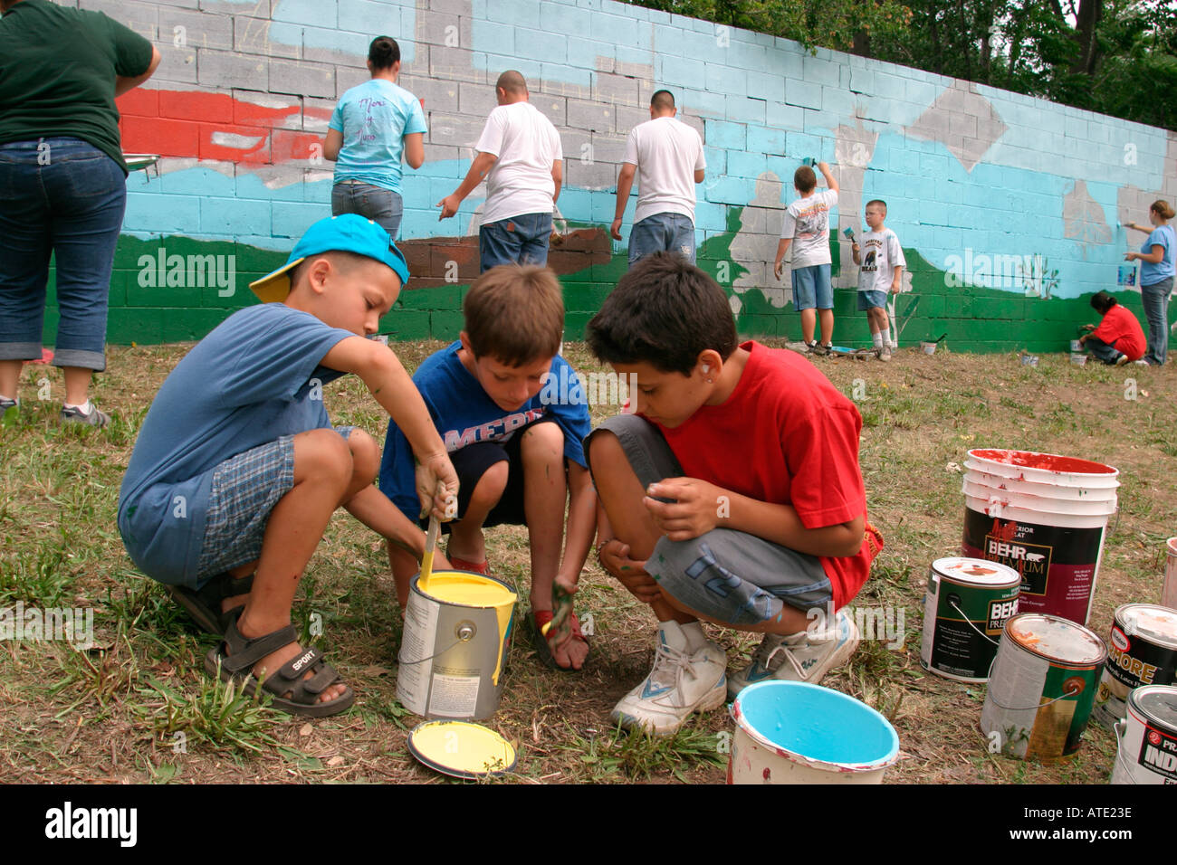 Peinture bénévoles un mur dans un quartier pauvre à Detroit Banque D'Images
