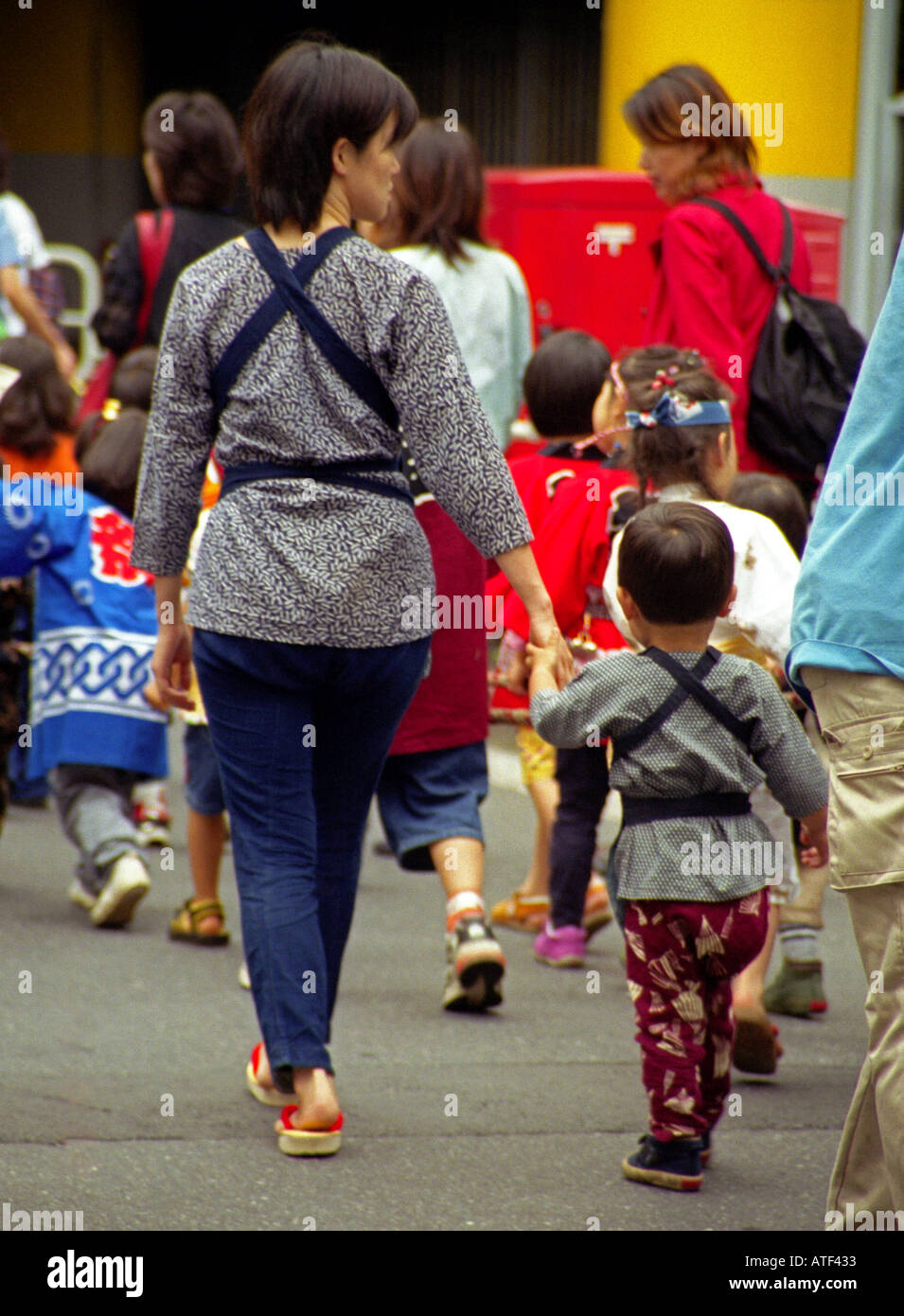 Portrait femme fils tenir la main à pied rendez-vous transporter même sac outdoor street road célébrer Festival Sanno Tokyo Japon Asie Orientale Banque D'Images