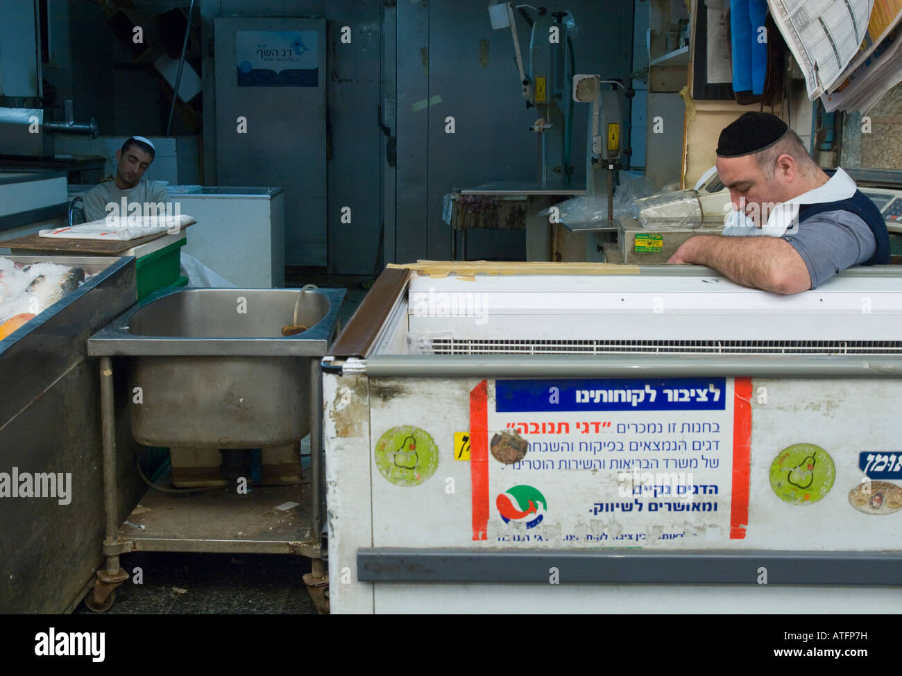 Israël Jérusalem marché Mahane Yehuda deux hommes endormis à leur étal de poisson Banque D'Images