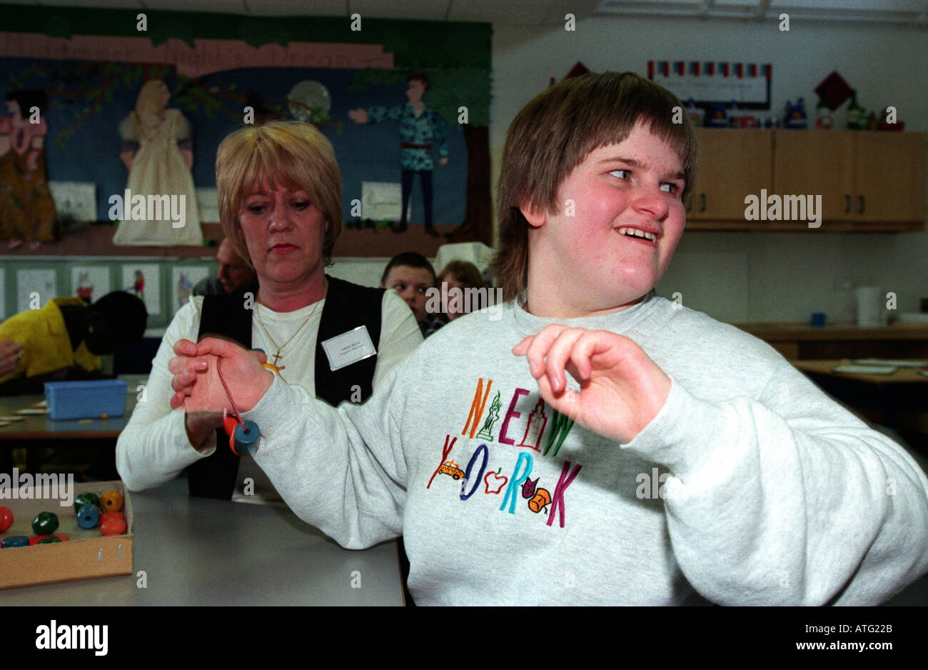 Jeune garçon autiste avec assistant à une école spéciale Middlesex Hillingdon Angleterre Banque D'Images