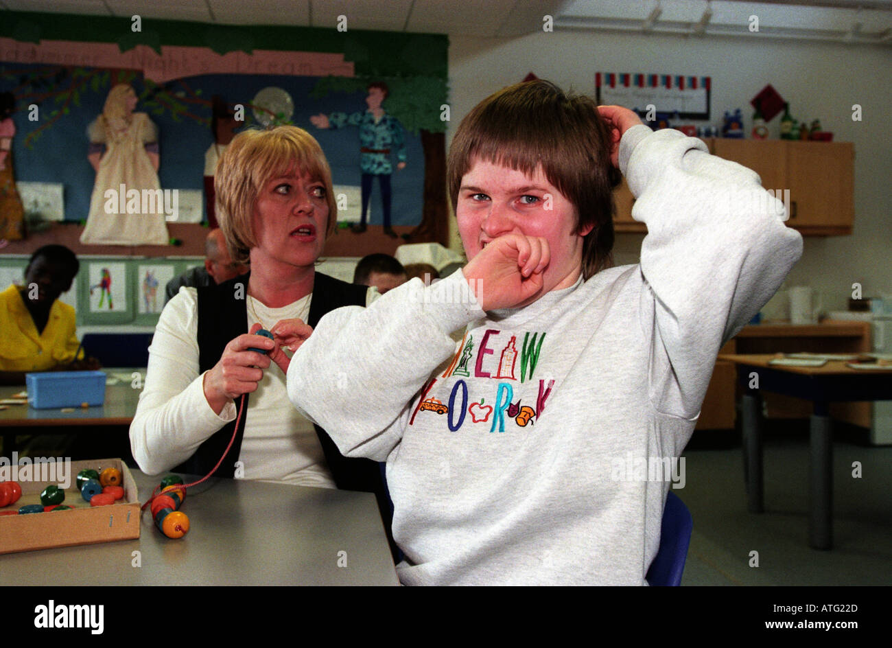 Jeune garçon autiste avec assistant à une école spéciale, Hillingdon, Middlesex, Angleterre. Banque D'Images