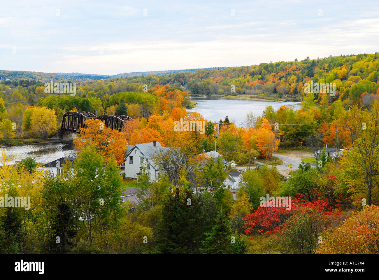 Image d'un pont ferroviaire sur la rivière Miramichi calme avec toutes les couleurs de l'automne autour de Banque D'Images