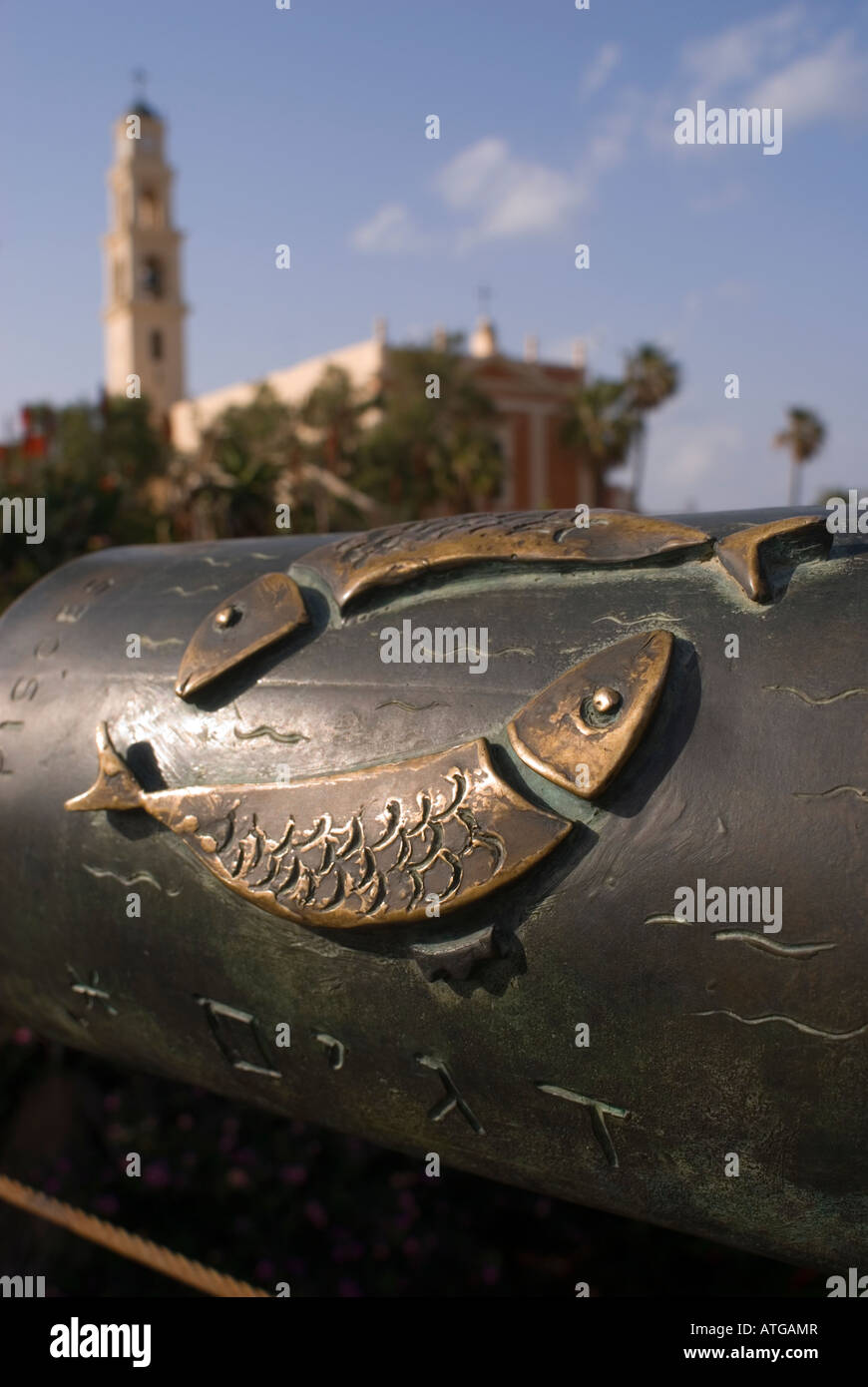 Relief du signe astrologique des poissons dans le bannister du 'Pont de souhaitant' avec l'église Saint-Pierre en arrière-plan, Old Jaffa Israël Banque D'Images