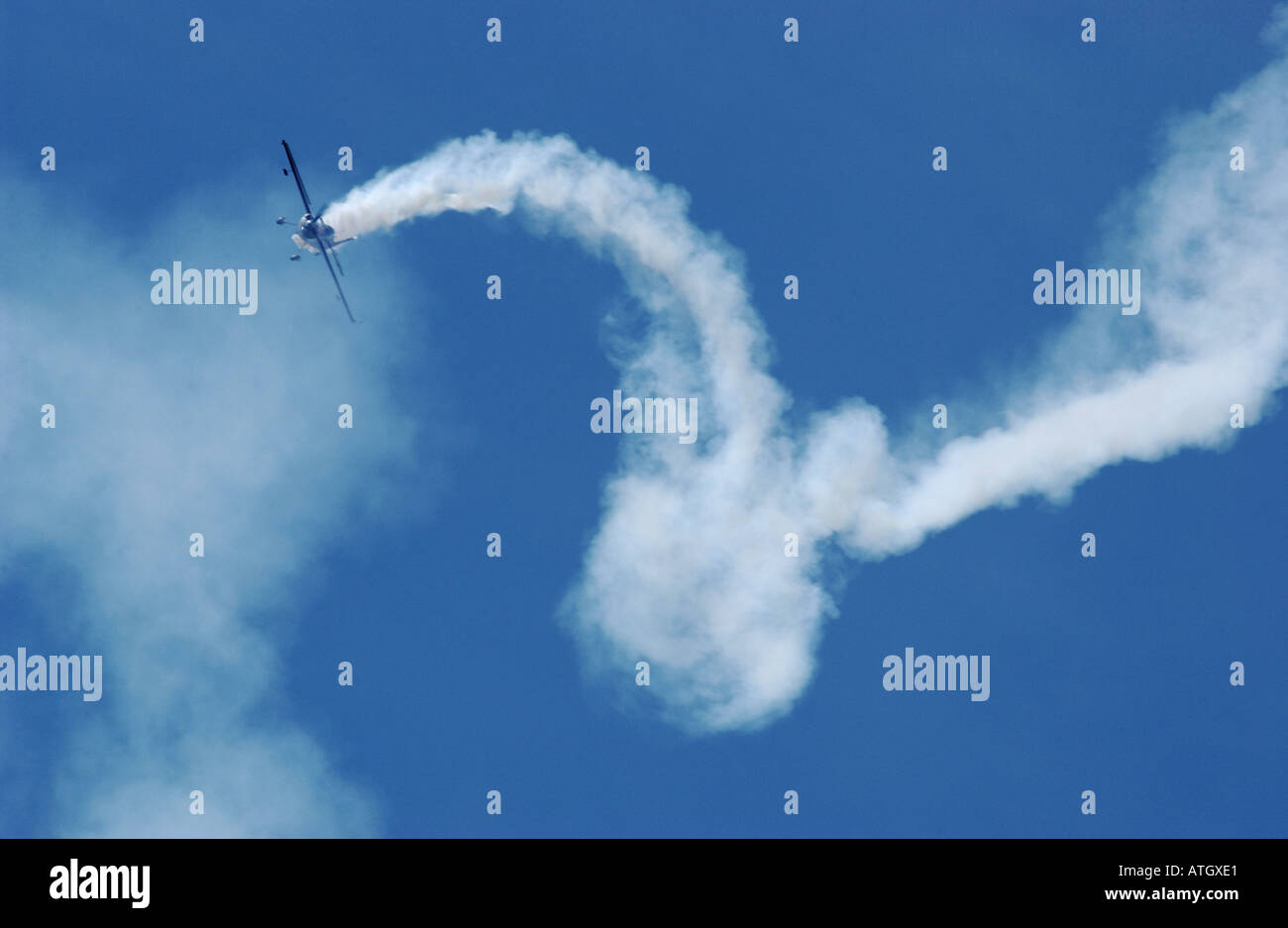 La voltige avec traînée de fumée d'un petit avion au-dessus de l'aéroport de Shoreham. Banque D'Images