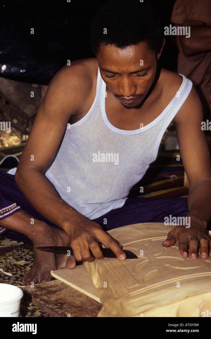 Abidjan Côte d'Ivoire Côte d'Ivoire. Travailleur du cuir touareg maliens Taher Saleh sculpte en bois recouverte de cuir sur la conception de boîte de rangement. Banque D'Images