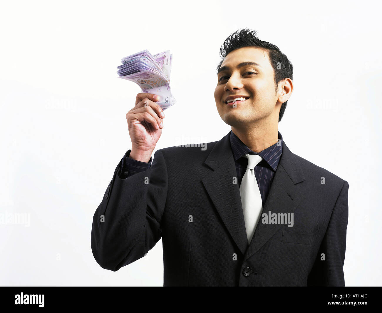 Businessman holding pile d'argent Banque D'Images