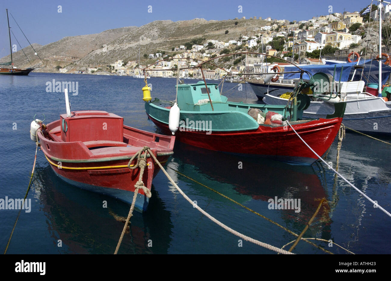 Peu de bateaux de pêche bob dans le paisible port sur l'île de Symi Banque D'Images