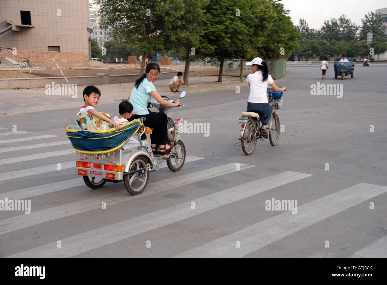 Mère avec des enfants sur un tricycle rickshaw Shangqiu City dans la province du Henan Chine Asie Banque D'Images
