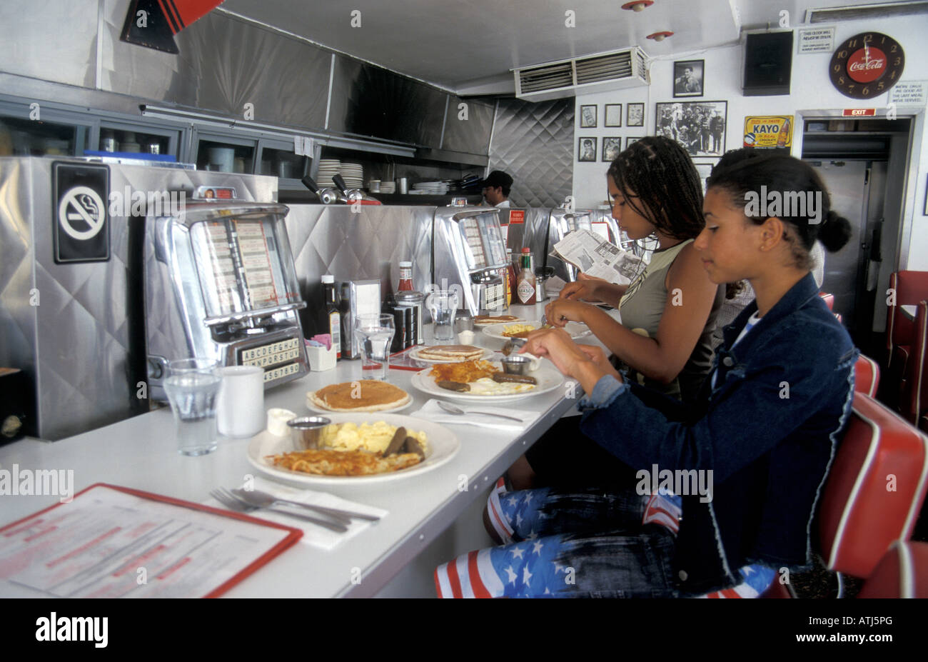 2 jeunes filles de manger le petit déjeuner aux crêpes américain typique dans American diner avec retro juke-boxes au bar Los Angeles California Banque D'Images