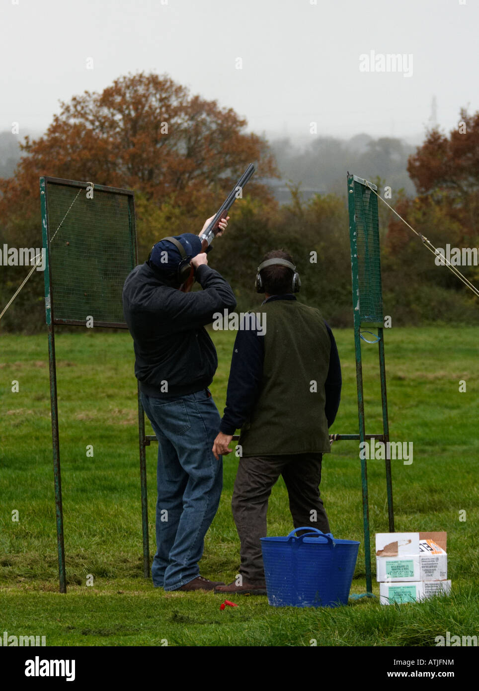 Deux hommes le tir au pigeon d'argile avec un fusil de chasse à la campagne dans le Wiltshire england uk Banque D'Images