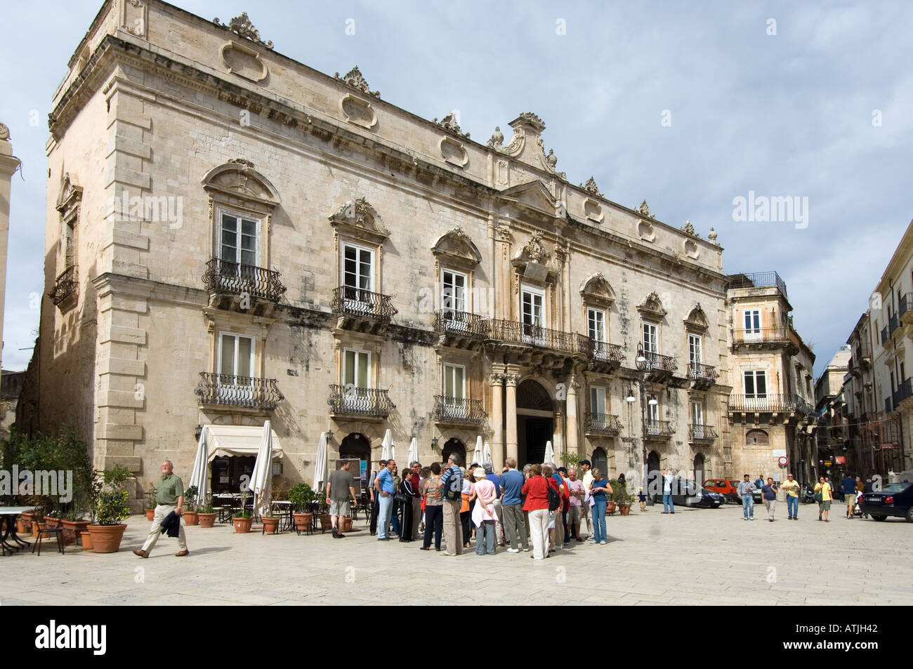 Un groupe de touristes écouter un guide sur la Piazza del Duomo, Syracuse, Sicile en face de Palazzo Ortigia Banque D'Images