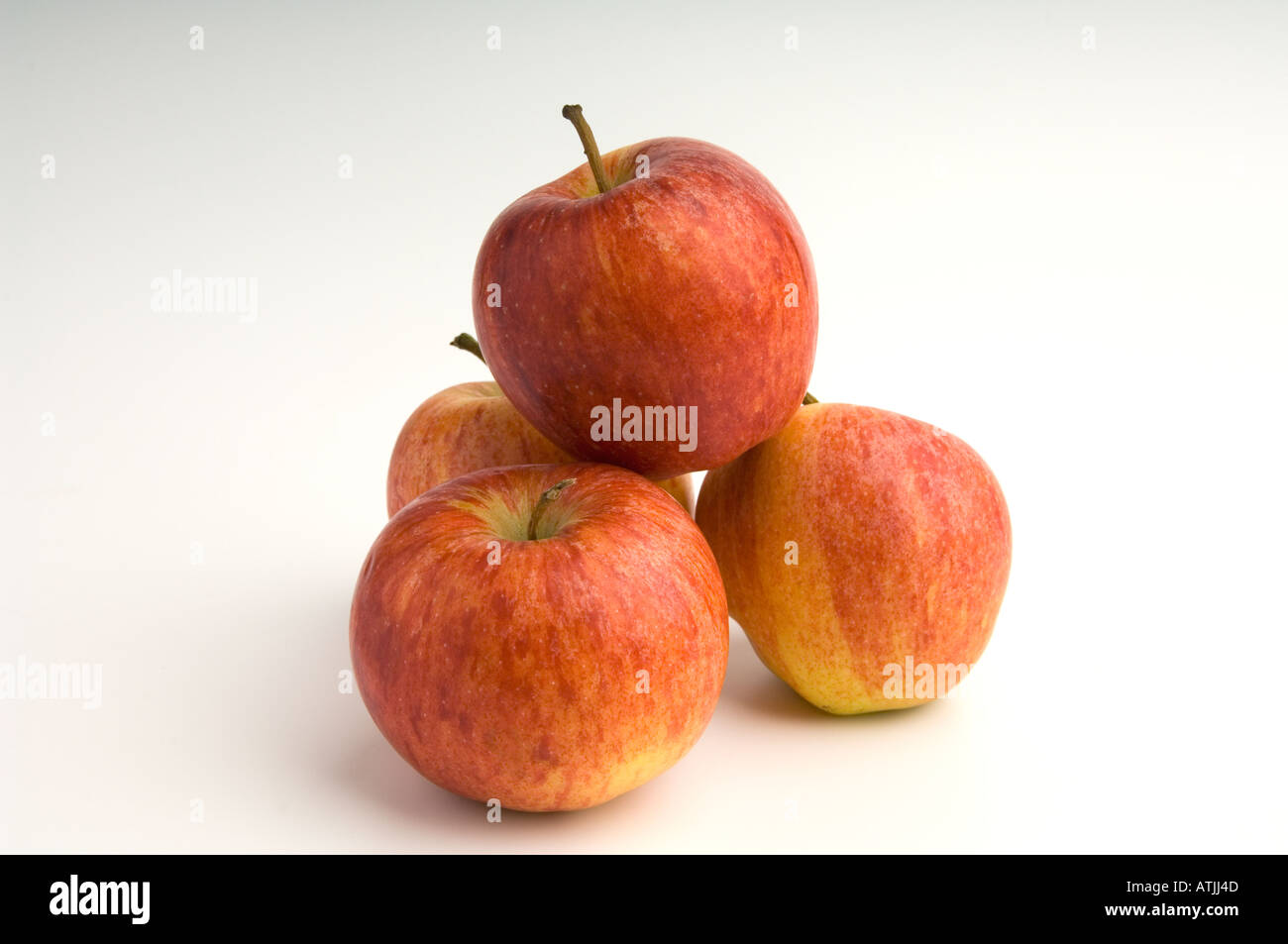 Pommes - un monticule de quatre pommes Gala sur fond blanc Banque D'Images