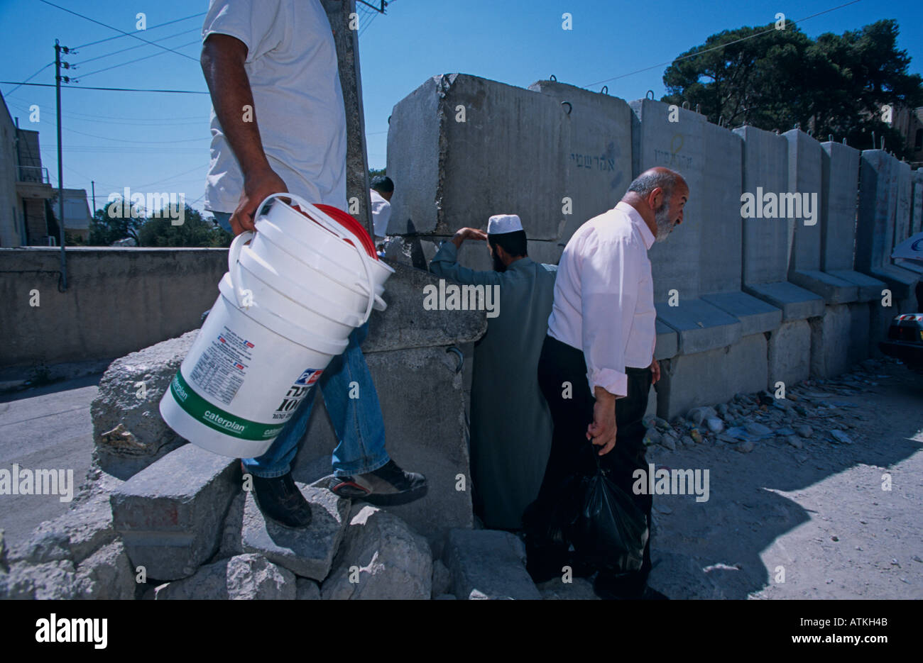 Les hommes en franchissant le mur à Abu Dis Jérusalem Banque D'Images