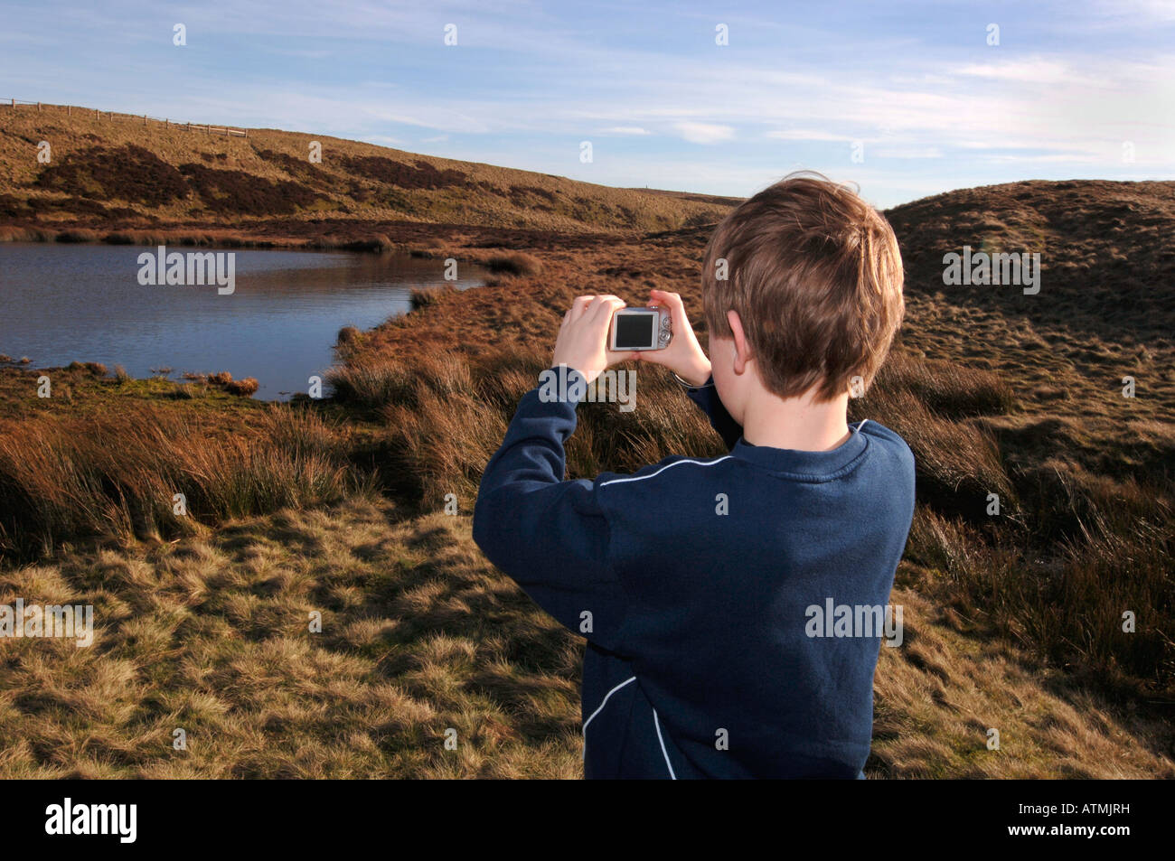Un garçon de 13 ans à l'aide d'un appareil photo numérique, sur le Staffordshire Moorlands. Banque D'Images