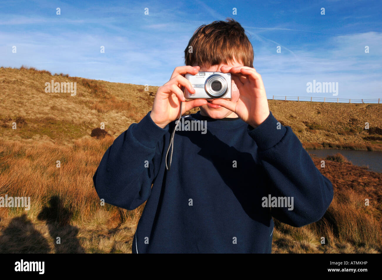 Un garçon de 13 ans à l'aide d'un appareil photo numérique, sur le Staffordshire Moorlands. Banque D'Images