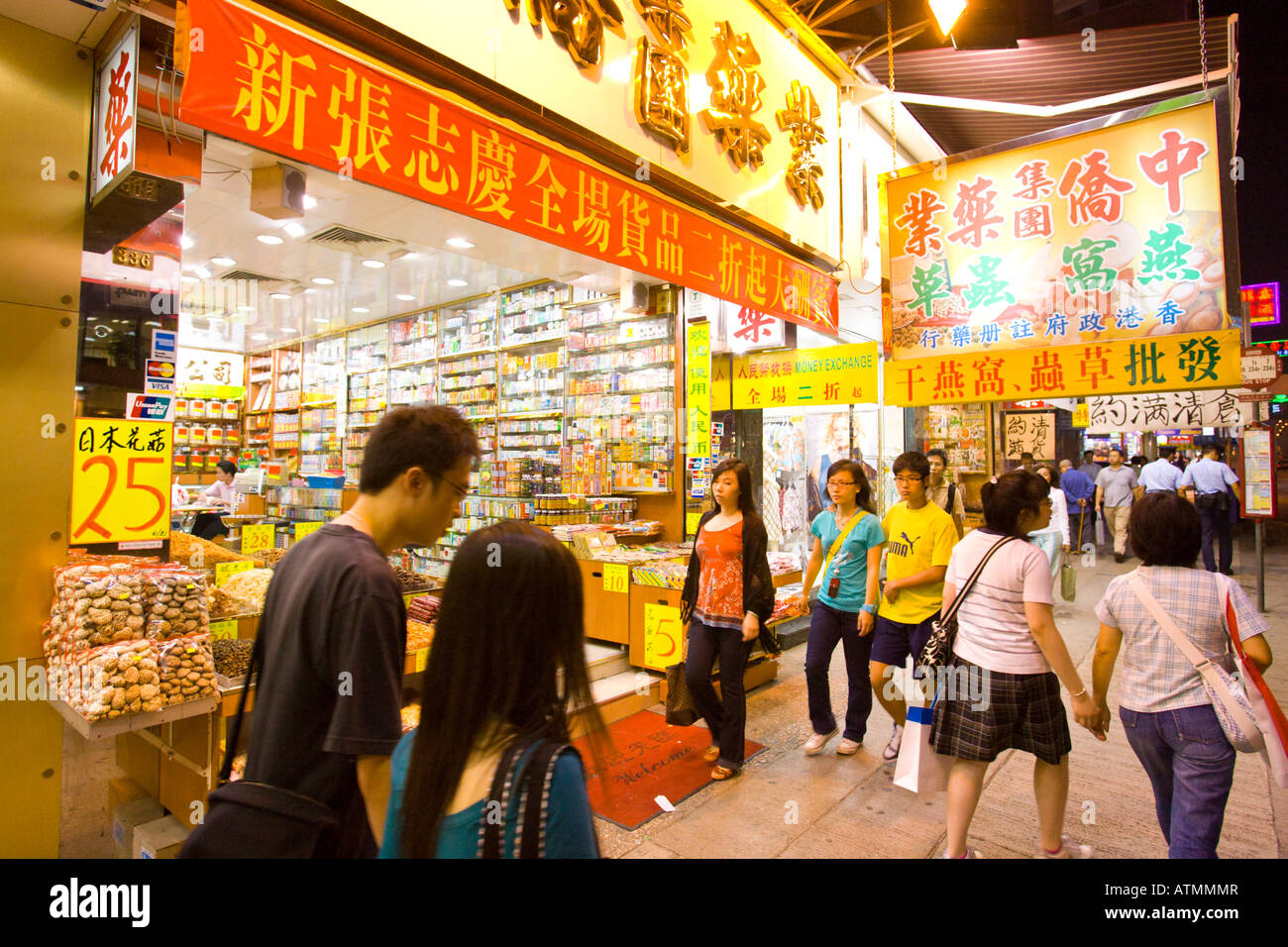 HONG KONG Chine Personnes sur un trottoir le long de Nathan Road Kowloon dans la nuit Banque D'Images