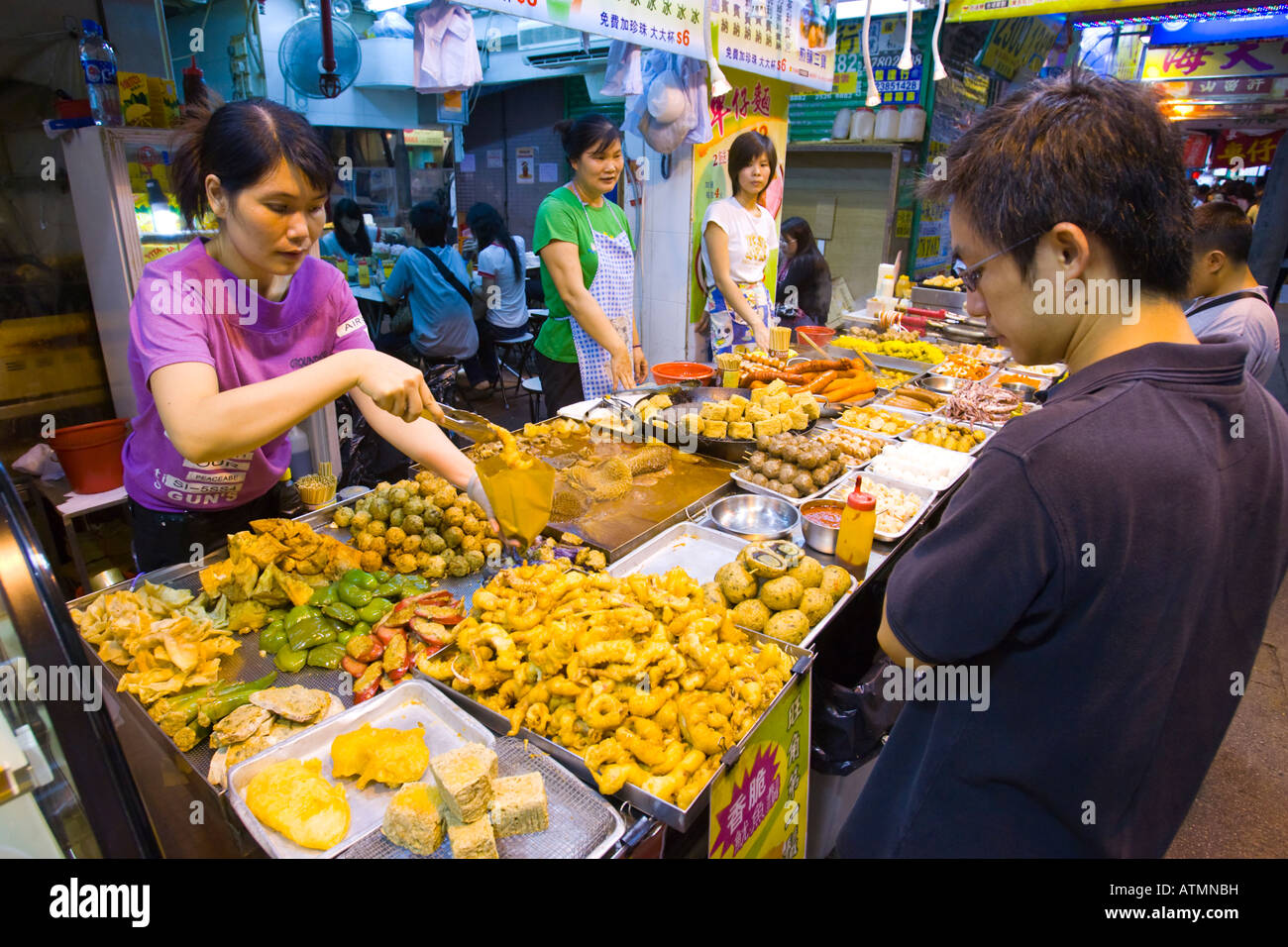 HONG KONG Chine Food Vendor sur trottoir dans la nuit dans le quartier animé de Kowloon Kowloon Banque D'Images