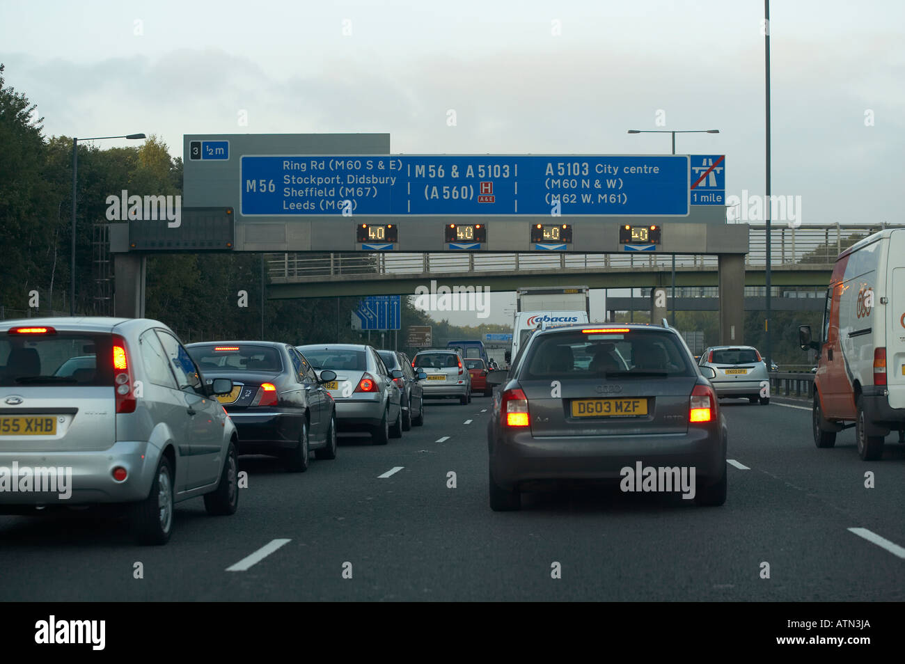 Les voitures AVEC FEUX DE DÉTRESSE CLIGNOTANT EN ATTENTE DE TRAFIC SUR L'AUTOROUTE M56 Banque D'Images