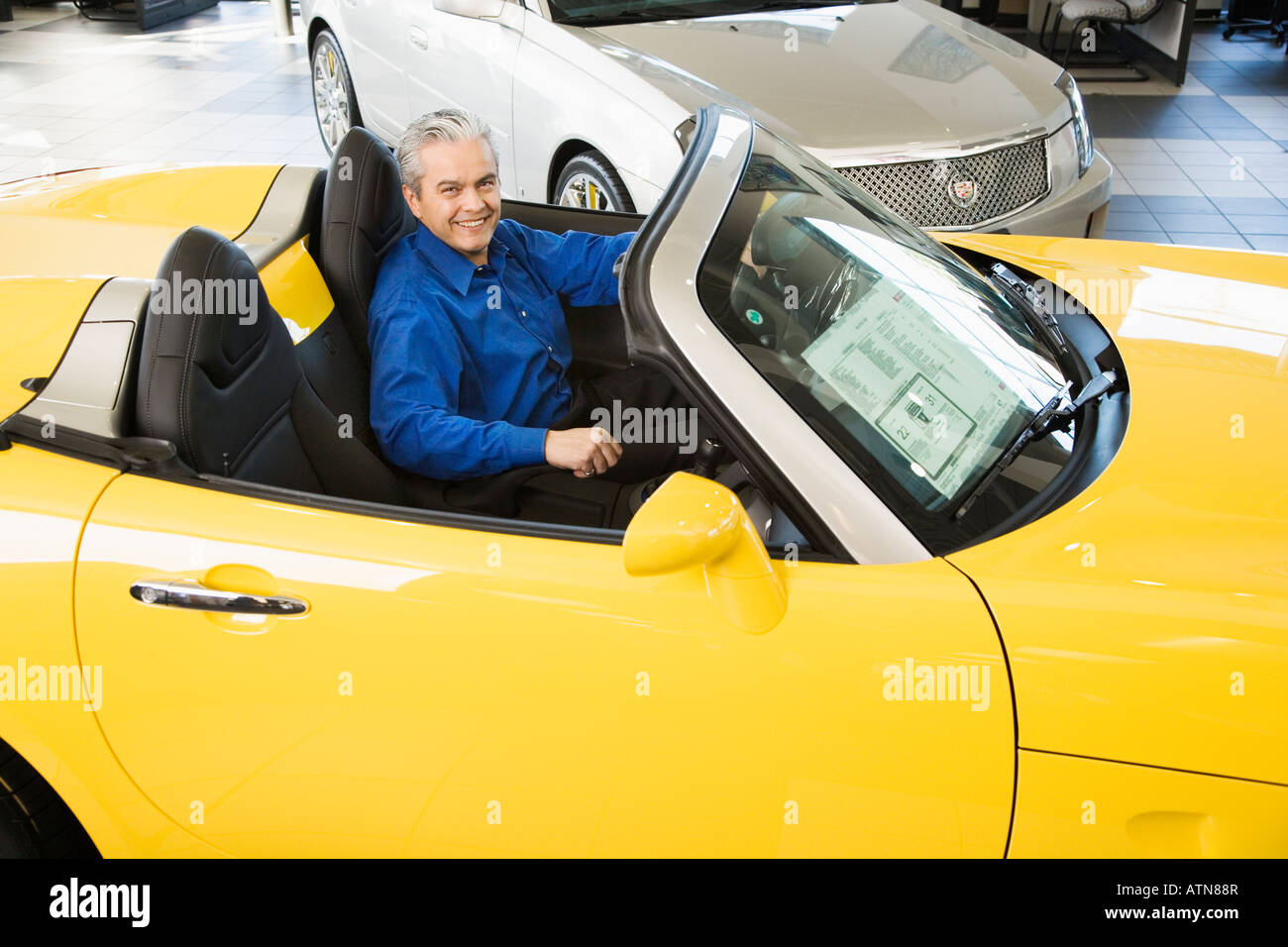 Vendeur de voiture hispaniques sitting in new car Banque D'Images