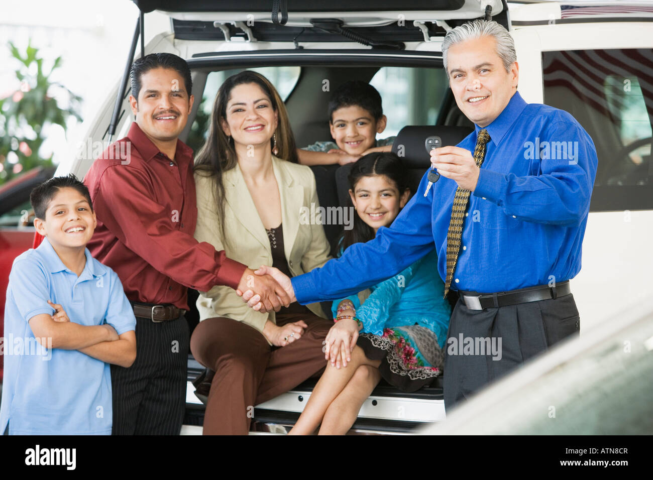Vendeur de voiture hispaniques remise des clés de voiture dans la famille Banque D'Images