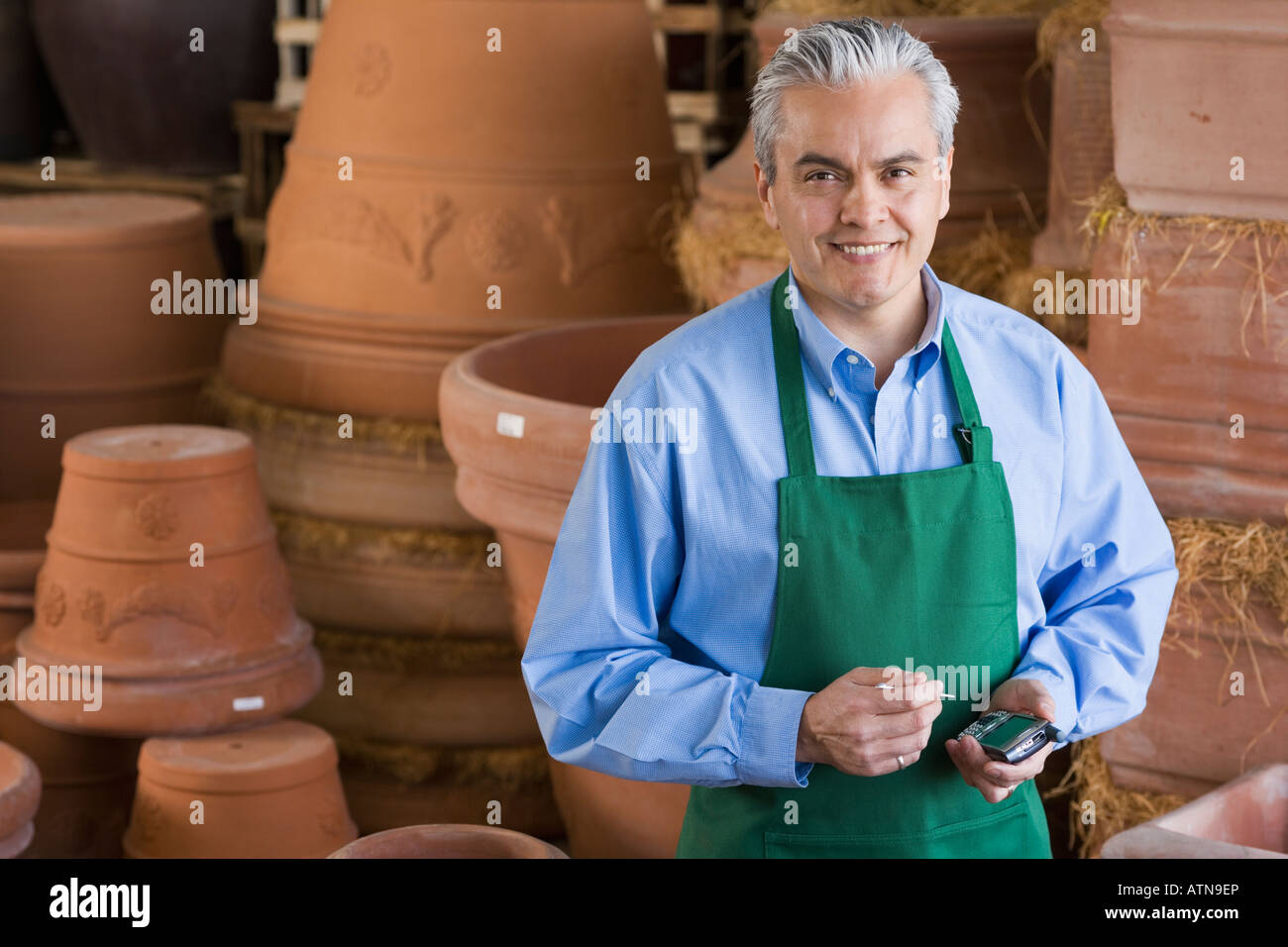 Hispanic man working at garden centre Banque D'Images