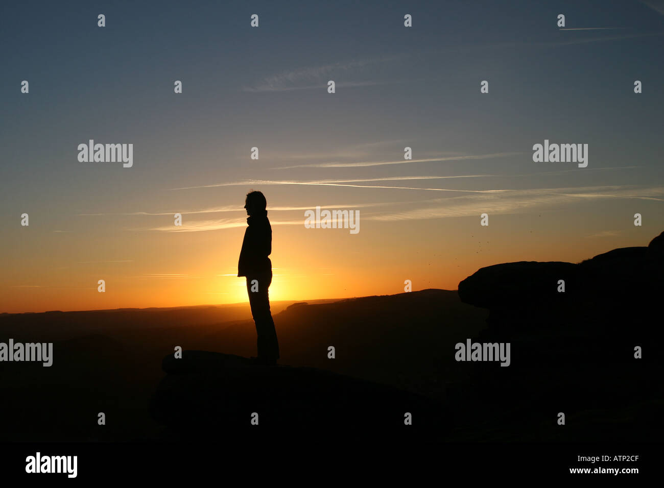 Silhouette d'une jeune fille au coucher du soleil dans le Derbyshire Peak District England UK Banque D'Images