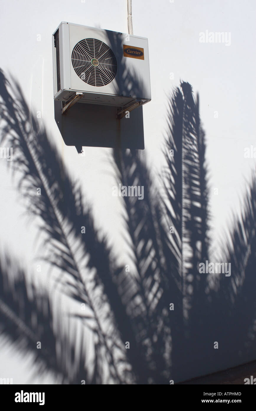 Palm tree jette une ombre sur un mur blanc appartement en vacances et c'est l'unité de climatisation Banque D'Images