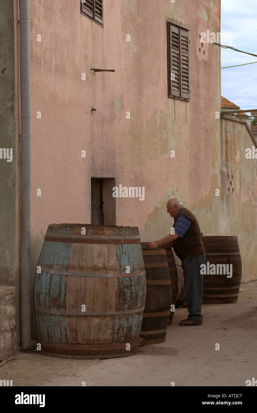 Un viticulteur avec de vieux tonneaux de vin en bois dans la rue dans la ville de Nin Croatie Banque D'Images