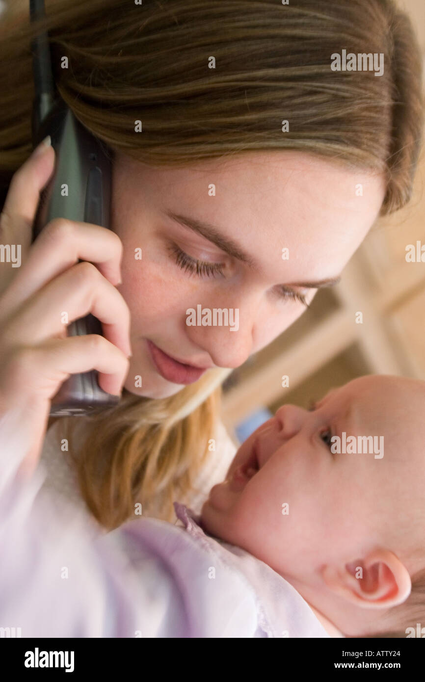 Jeune Mere D Essayer De Parler Au Telephone Tout En Tenant Son Bebe Pleurer Photo Stock Alamy