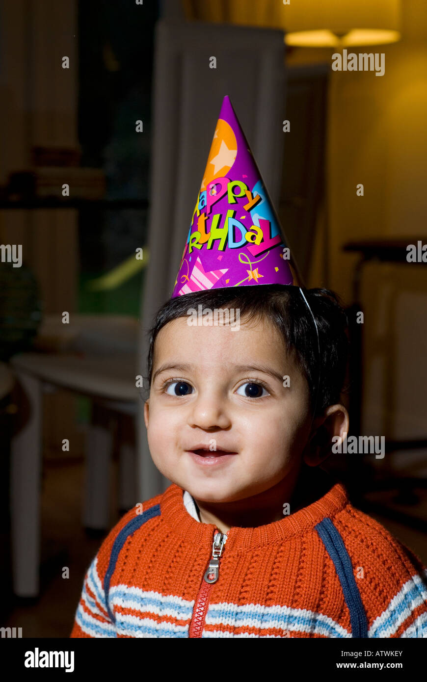 Un an baby boy wearing hat cone joyeux anniversaire Banque D'Images