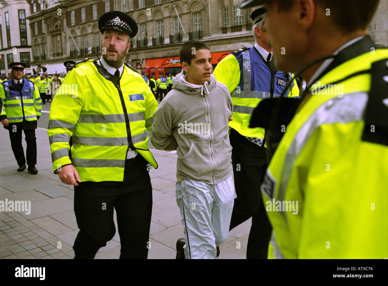 Les agents de police à l'arrestation d'un jeune homme lors d'une manifestation dans le centre de Londres, Mayday 2003. Banque D'Images