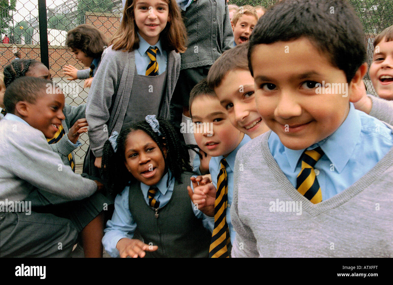 Groupe d'enfants jouant dans l'école primaire de cour d'école. Banque D'Images