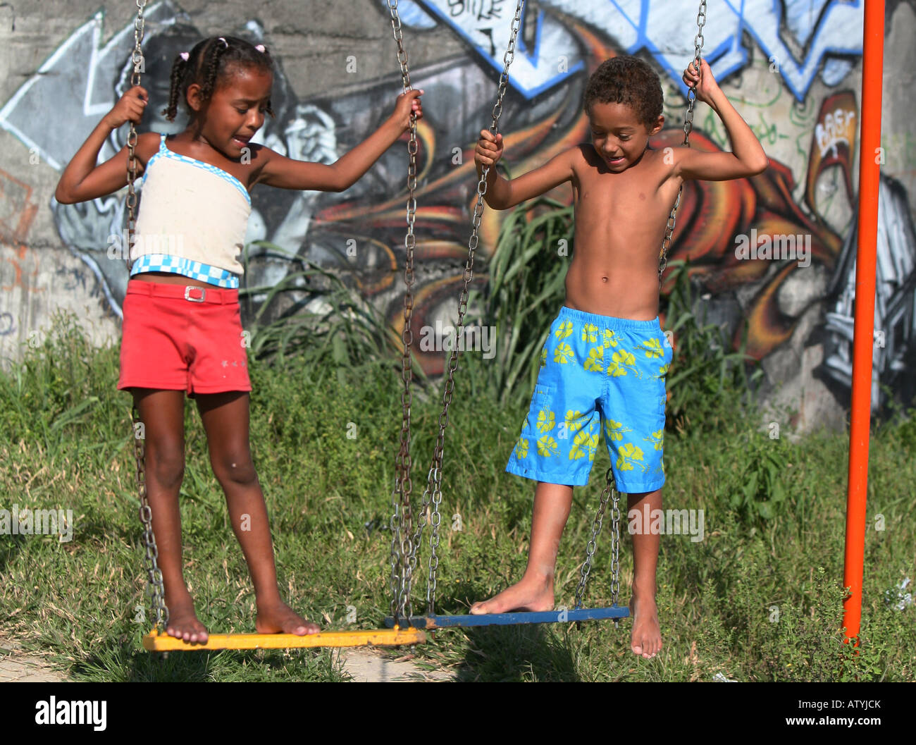 Les enfants jouent sur la balançoire dans la favela de Rio de Janeiro, Brésil graffiti avec des taudis, de l'Amérique du Sud Banque D'Images