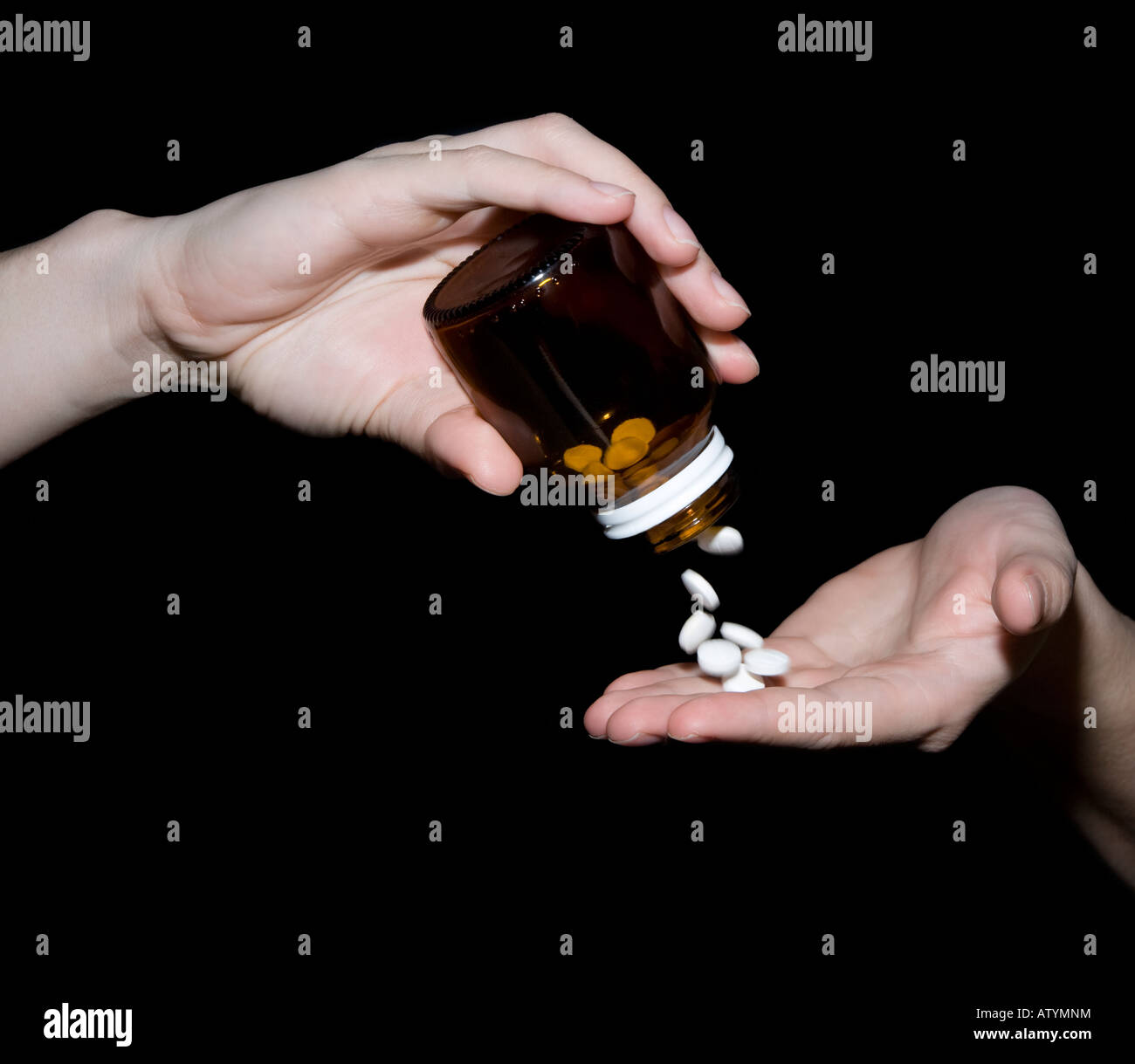 Un woman pouring pills à partir d'une bouteille. Banque D'Images