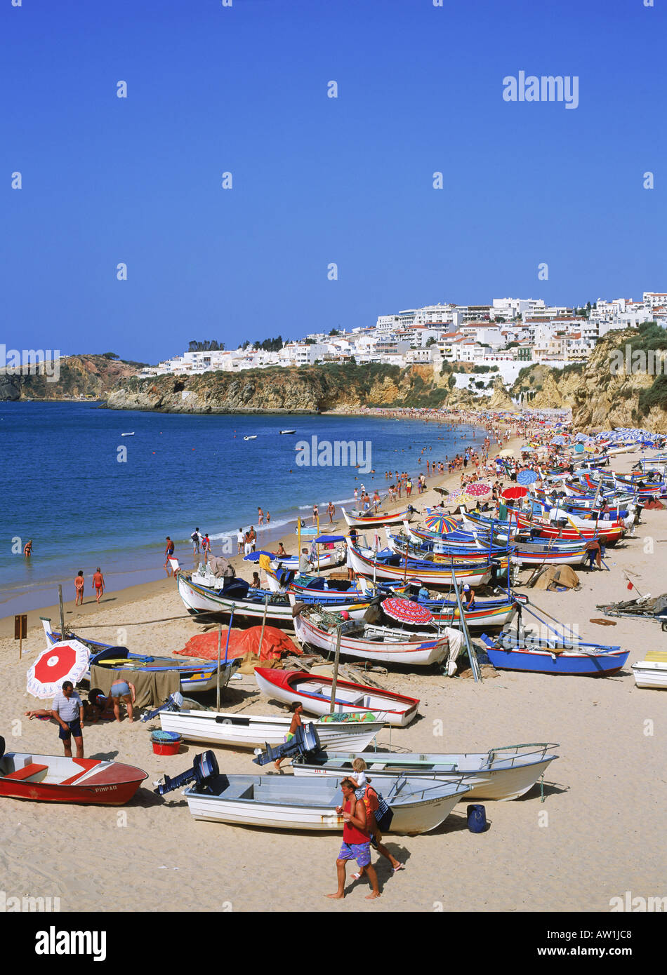 Bateaux de pêche colorés et les touristes sur la plage d'Albufeira en Algarve, Portugal Banque D'Images