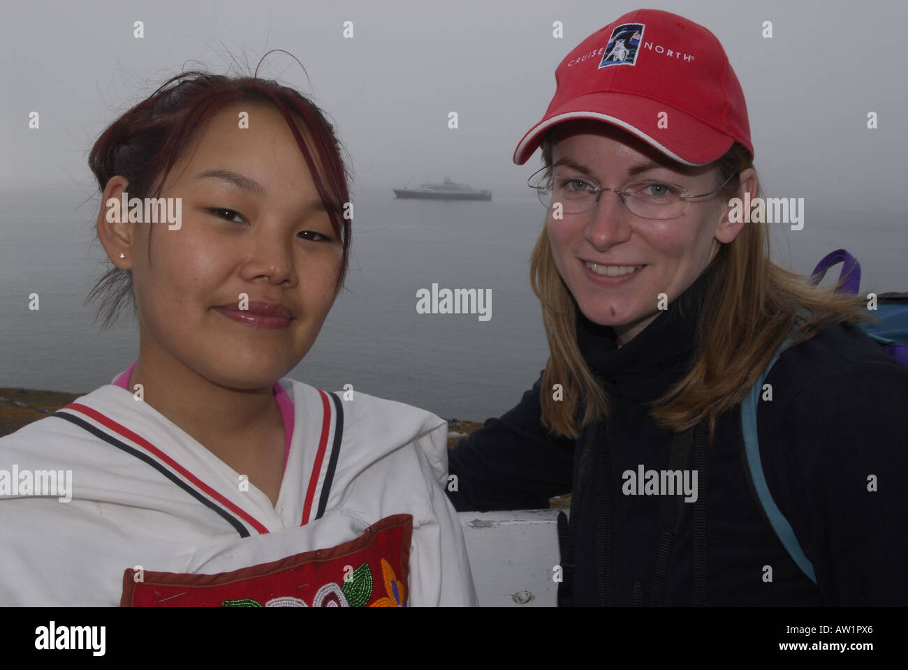 Le chant de gorge inuit teens portant leurs vêtements traditionnels avec l'île de Baffin, chef de Pond Inlet High Arctic Canada touristiques éloignées isolées brouillard randonnée rock rockly langue les bottes habillées de folklore local Banque D'Images