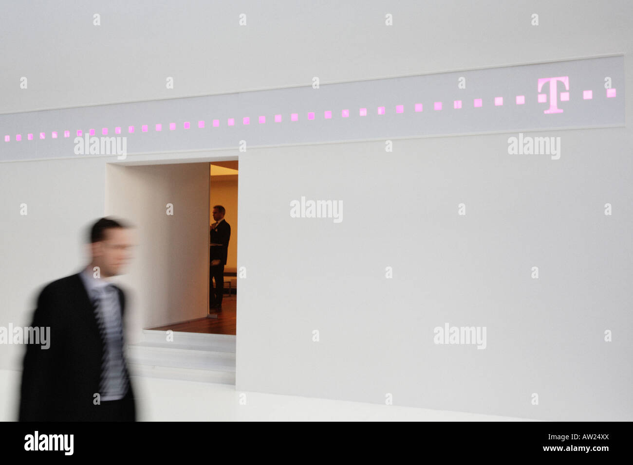 Allemagne Hanovre 2008 Salon CeBIT - UN fairgoer passe devant le stand de Deutsche Telekom Banque D'Images