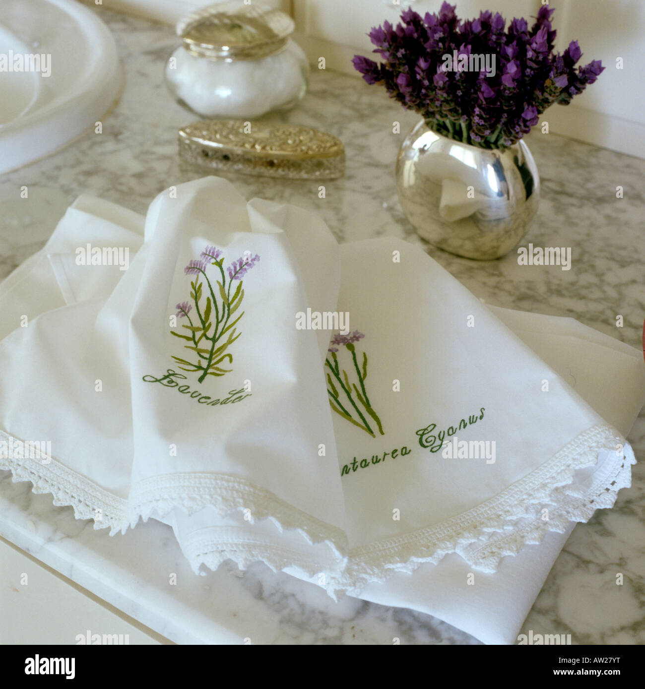 Petites serviettes en coton avec motif fleur brodée main sur surface en marbre Banque D'Images