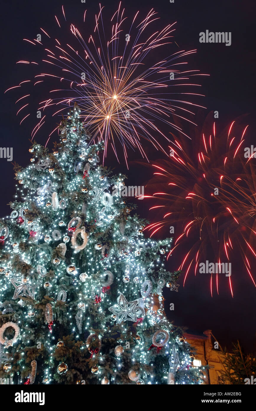 Arbre de Noël en plein air géant lumineux et éclatant d'artifice au-dessus dans le ciel nocturne pour célébrer le Jour de l'An Banque D'Images