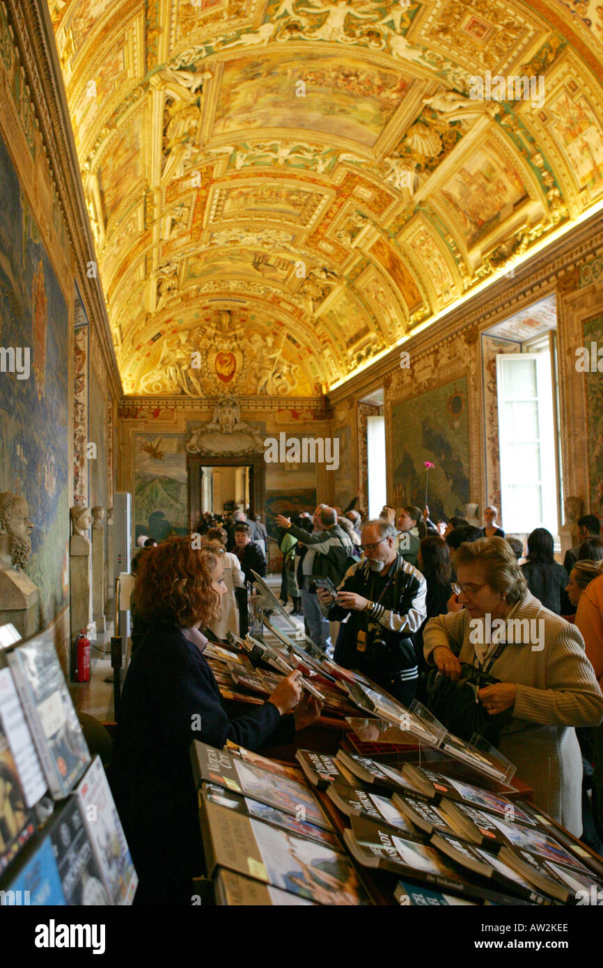 Guides touristes achètent souvenirs du souvenir de Musée du Vatican le personnel de cabine de l'intérieur d'un couloir lumineux, Rome Italie Europe Banque D'Images