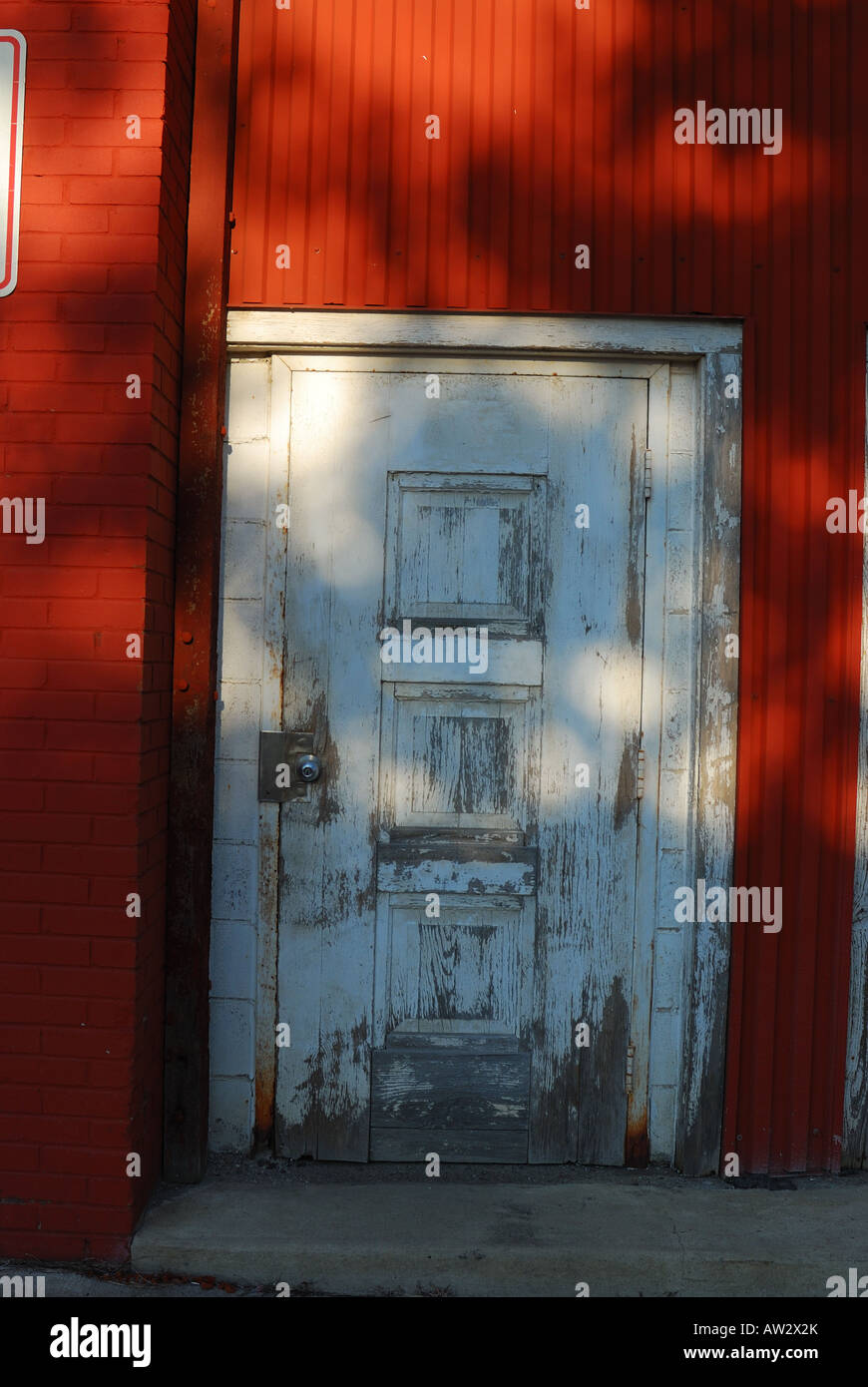 Blanc patiné porte dans un mur rouge Banque D'Images