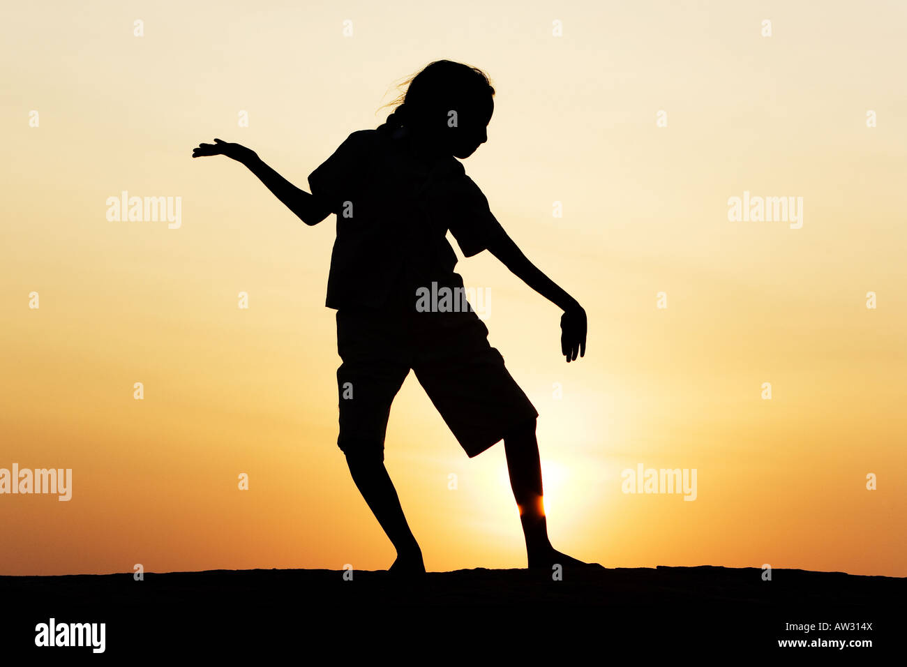 Indian girl dancing silhouette sur un rocher au coucher du soleil. L'Inde Banque D'Images