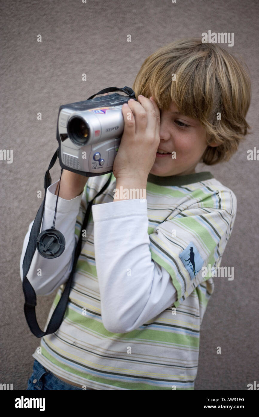 Garçon de huit ans de filmer à l'aide d'une caméra vidéo à l'extérieur Banque D'Images