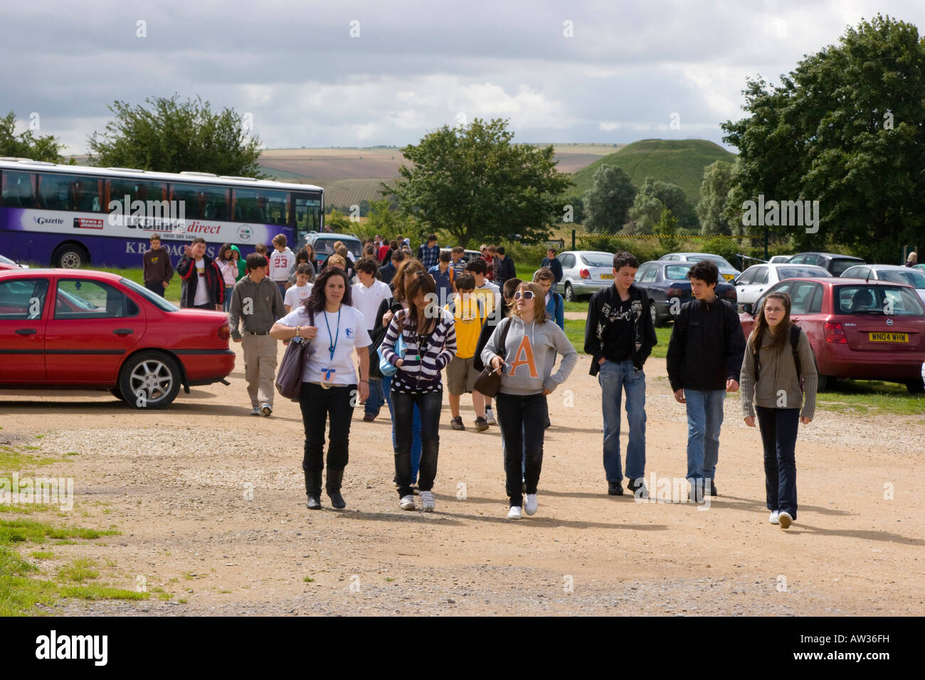 Les visiteurs dans le parking à Avebury à Silbury Hill dans l'arrière-plan Banque D'Images