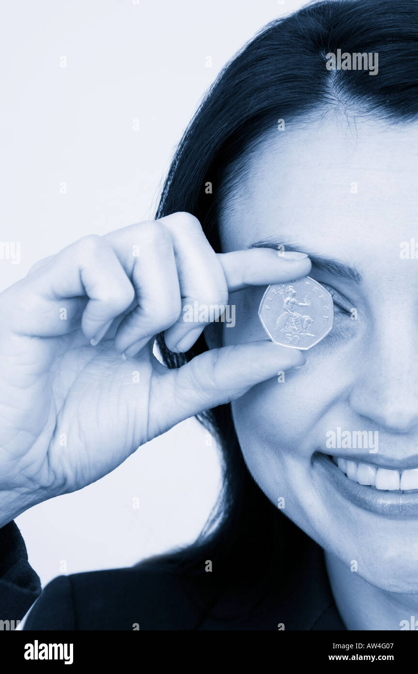 Femme avec une pièce de 50 pence jusqu'à l'œil Banque D'Images