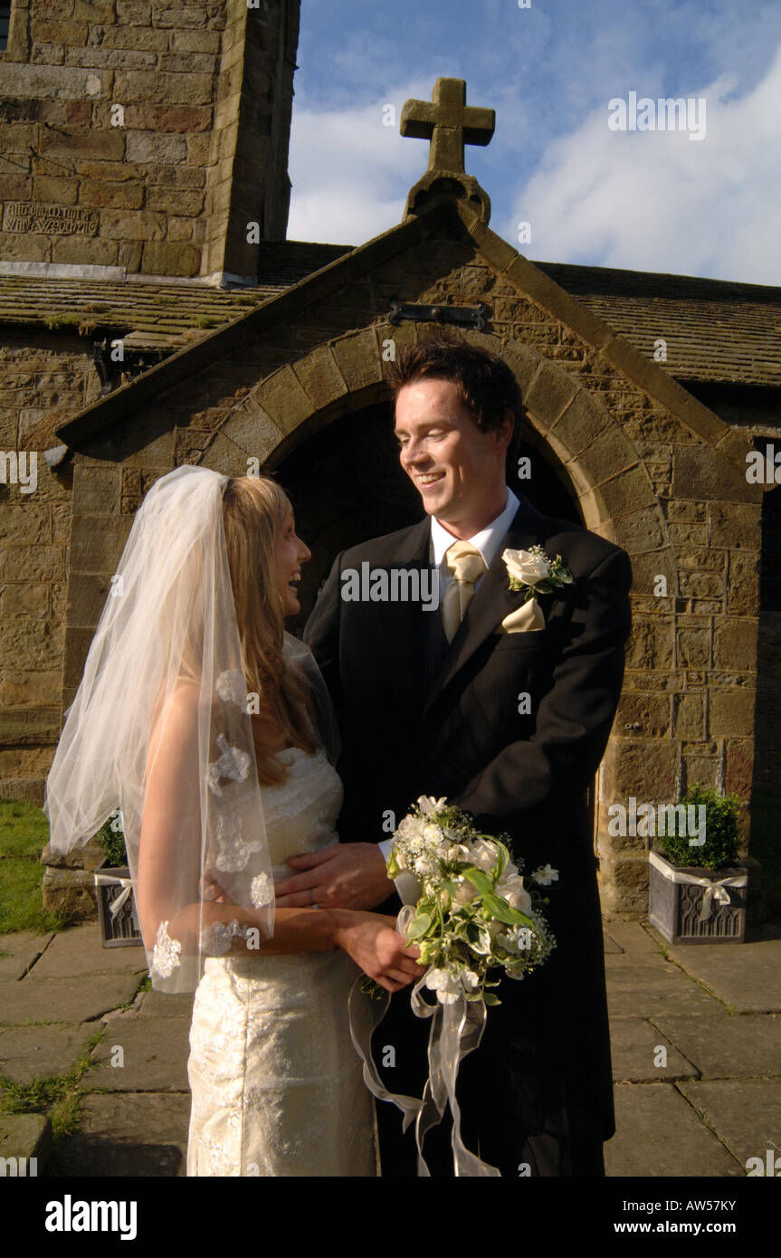Un couple à l'extérieur de l'église après son mariage Parution Modèle Banque D'Images