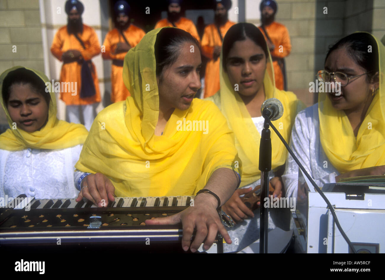 Les jeunes femmes sikhes célèbrent l'anniversaire de la khalsa avec de la musique traditionnelle en dehors de Hounslow gurdwara, à Londres. Banque D'Images