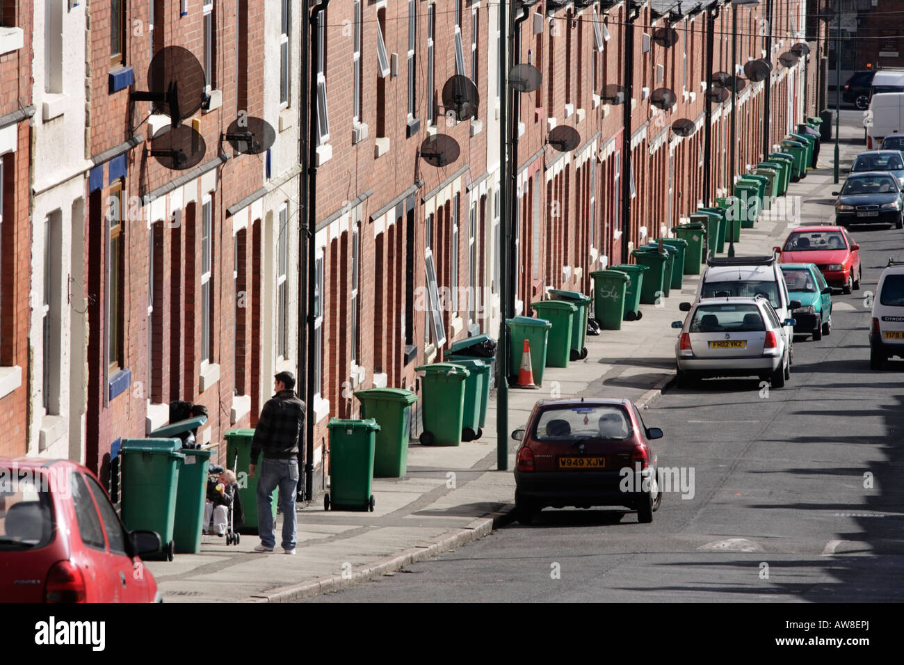 Une rangée de poubelles vertes en attente d'être recueillies sur un trottoir à Nottingham, Royaume-Uni Banque D'Images